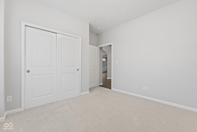 unfurnished bedroom featuring light carpet and a closet