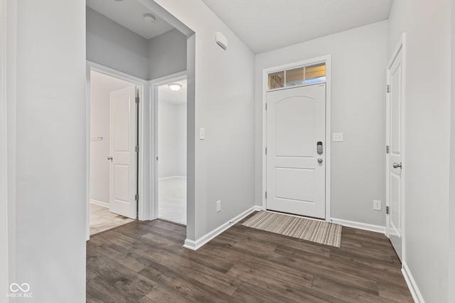 entryway with a textured ceiling and dark wood-type flooring