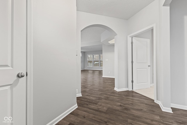 hall featuring a textured ceiling and dark wood-type flooring