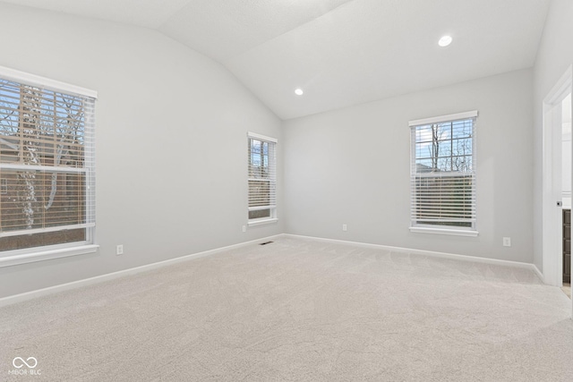 unfurnished room featuring light carpet and lofted ceiling