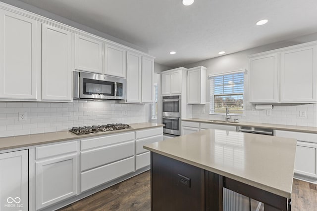 kitchen with white cabinetry, sink, stainless steel appliances, and dark hardwood / wood-style floors