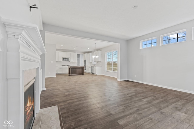 unfurnished living room featuring hardwood / wood-style flooring and an inviting chandelier