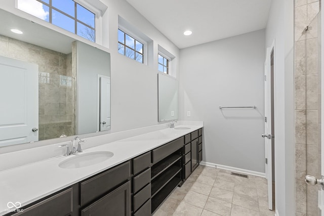 bathroom featuring a tile shower, vanity, and tile patterned floors