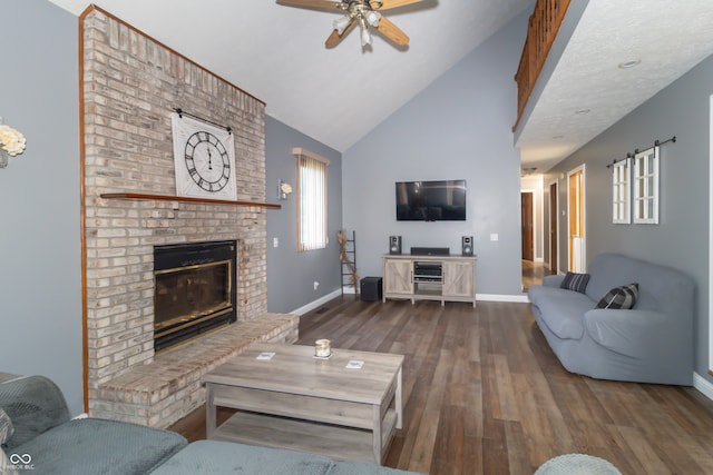 living room featuring ceiling fan, high vaulted ceiling, dark wood-type flooring, and a brick fireplace