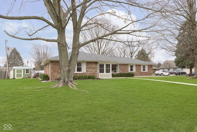 single story home with brick siding, a storage unit, an outbuilding, and a front yard