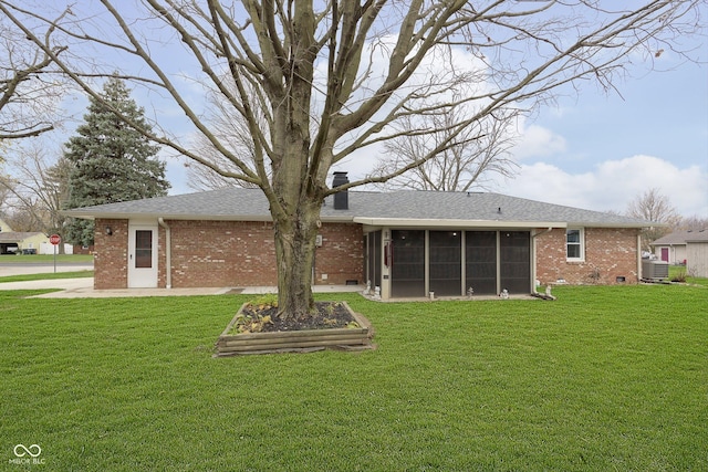 back of house featuring a lawn, brick siding, a sunroom, and crawl space