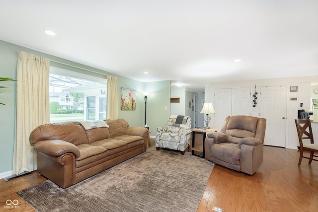 living area with recessed lighting, baseboards, and wood finished floors