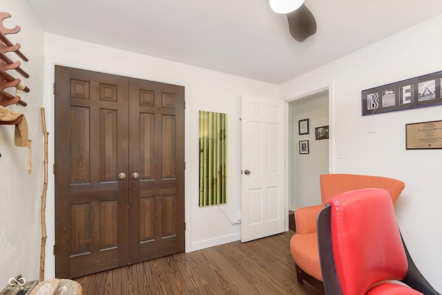 living area featuring dark wood-style floors, ceiling fan, and baseboards