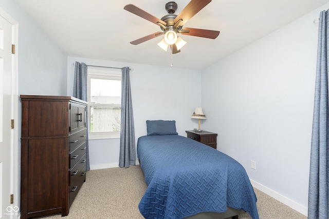 bedroom featuring light carpet, ceiling fan, and baseboards