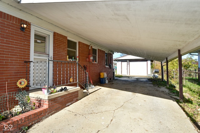 view of patio featuring an outbuilding, a garage, and a carport