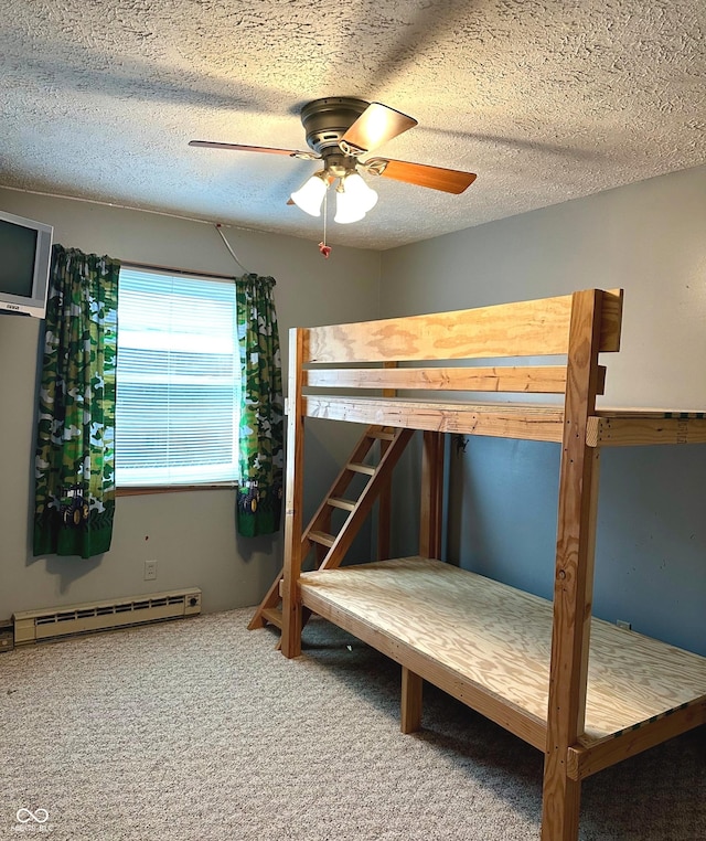 unfurnished bedroom with carpet flooring, ceiling fan, a textured ceiling, and a baseboard heating unit