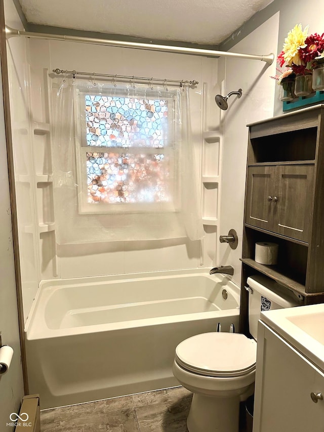 full bathroom with vanity, shower / bath combo, a textured ceiling, and toilet