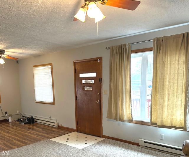 foyer featuring a textured ceiling, hardwood / wood-style flooring, plenty of natural light, and a baseboard heating unit