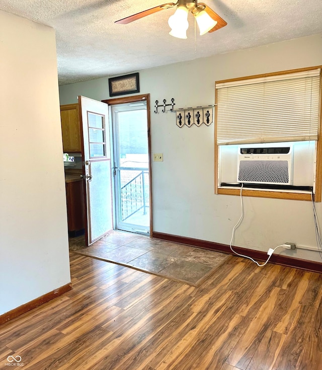 empty room with dark hardwood / wood-style floors, cooling unit, a textured ceiling, and ceiling fan