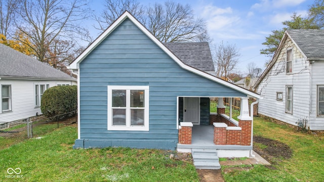 back of house featuring a porch and a yard