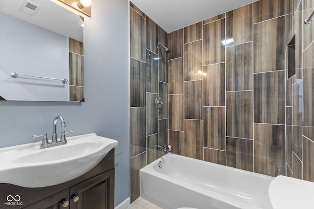 bathroom with vanity and tiled shower / bath combo