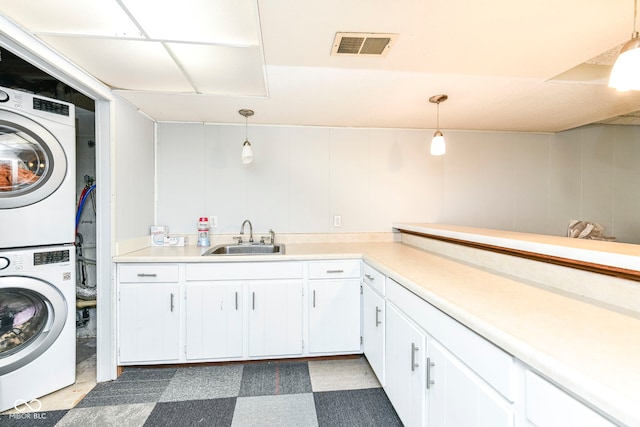 laundry area featuring sink and stacked washer / drying machine