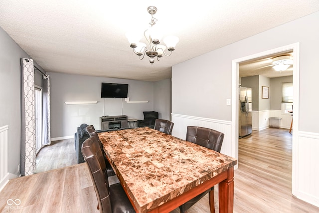 dining room featuring a textured ceiling and light hardwood / wood-style flooring