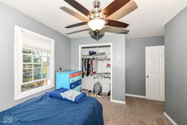 bedroom featuring carpet, ceiling fan, and a textured ceiling