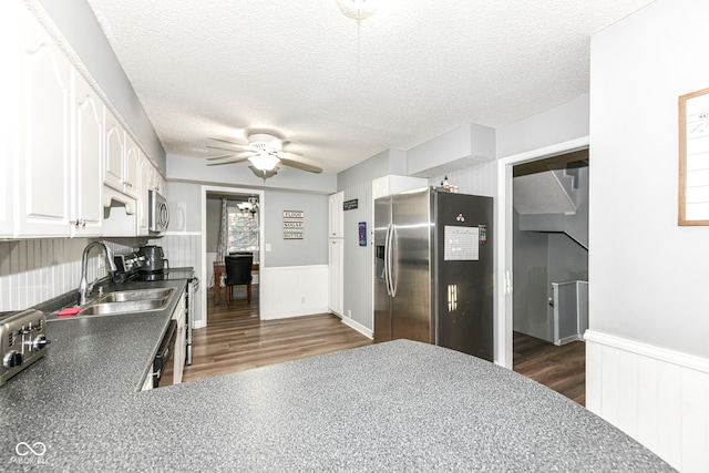 kitchen with white cabinets, a textured ceiling, stainless steel appliances, and dark wood-type flooring