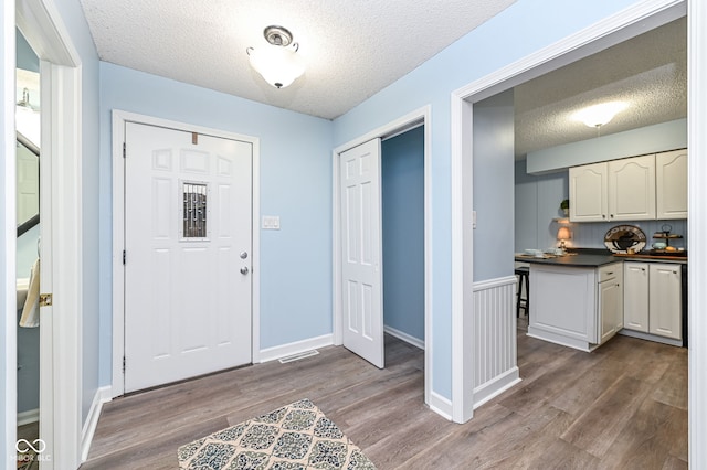 entrance foyer featuring dark hardwood / wood-style floors and a textured ceiling