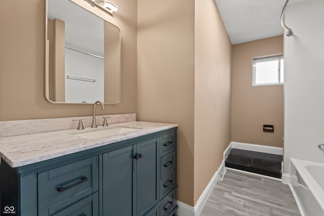 bathroom featuring vanity, a bath, and hardwood / wood-style flooring