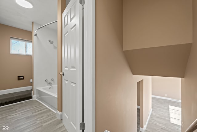 bathroom featuring hardwood / wood-style flooring and bathing tub / shower combination