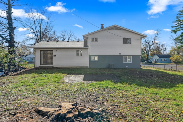 rear view of house featuring a lawn and central air condition unit