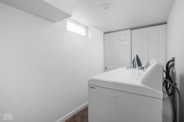 washroom with dark hardwood / wood-style flooring and washer / dryer