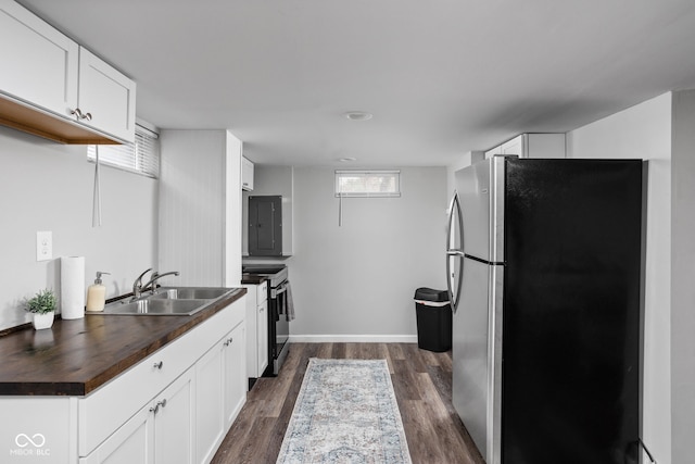 kitchen with white cabinets, appliances with stainless steel finishes, dark hardwood / wood-style floors, and sink