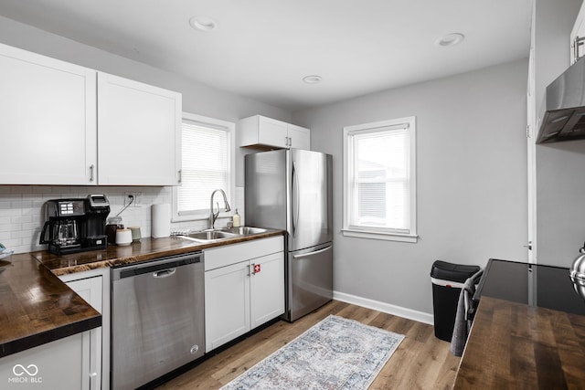 kitchen featuring appliances with stainless steel finishes, white cabinetry, a wealth of natural light, and sink