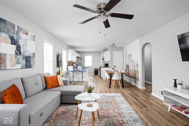 living room with light hardwood / wood-style flooring and ceiling fan