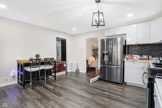 kitchen with stainless steel fridge, stove, white cabinetry, and dark wood-type flooring