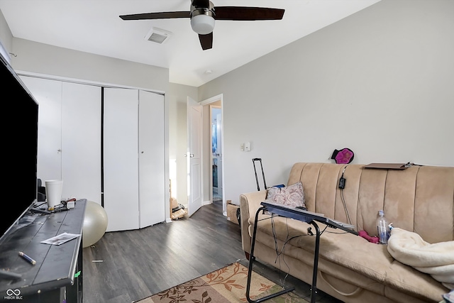 living room with ceiling fan and dark hardwood / wood-style flooring