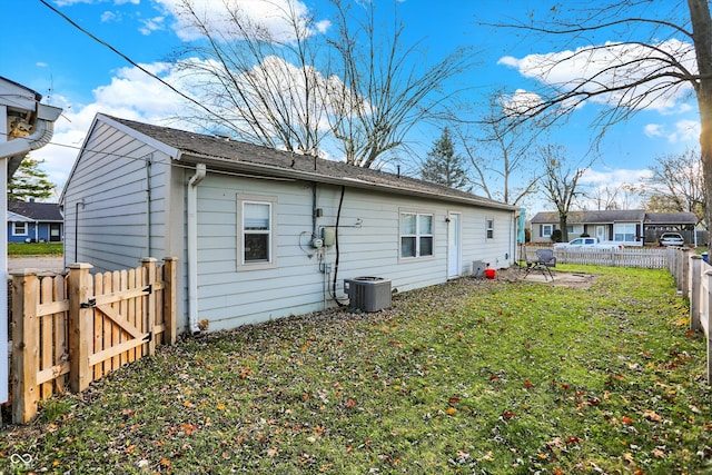 back of house with a yard and central AC unit