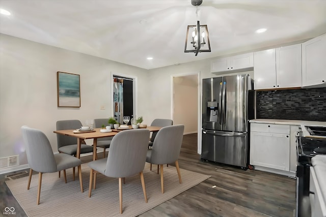 dining area with dark hardwood / wood-style flooring and a chandelier