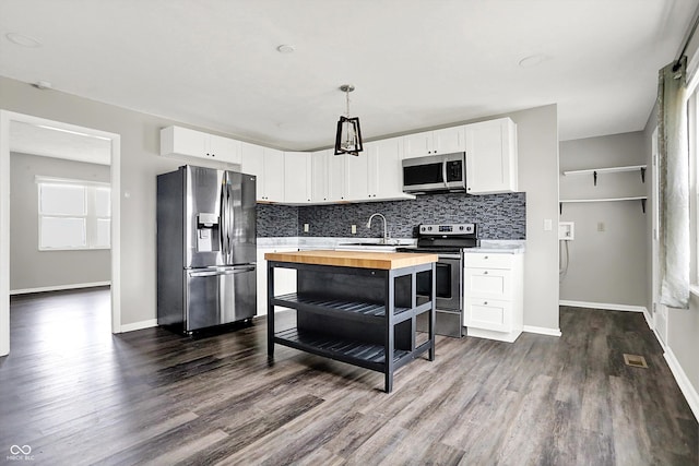 8902 Carla Dr, Indianapolis, IN 46219 - kitchen with butcher block countertops, sink, appliances with stainless steel finishes, white cabinets, and decorative light fixtures