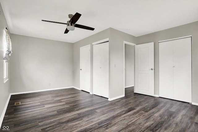 8902 Carla Dr, Indianapolis, IN 46219 - unfurnished bedroom with dark hardwood / wood-style flooring, two closets, and ceiling fan