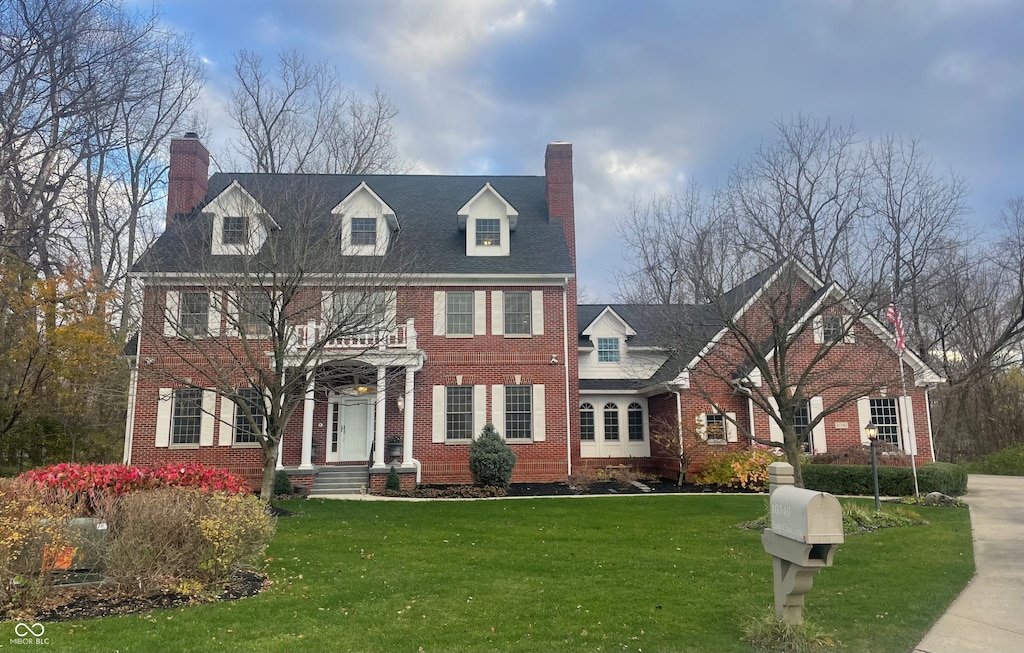 colonial home featuring a front lawn