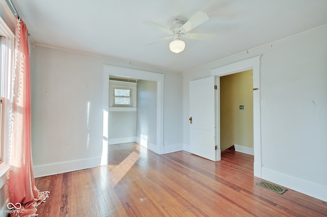 spare room featuring plenty of natural light, light hardwood / wood-style floors, ornamental molding, and ceiling fan