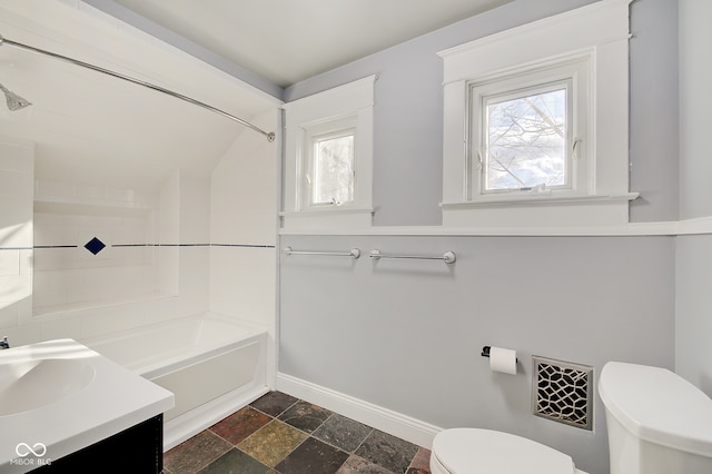 full bathroom with tiled shower / bath, vanity, and toilet