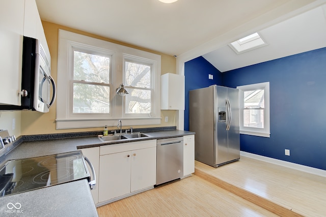 kitchen with white cabinets, plenty of natural light, sink, and stainless steel appliances