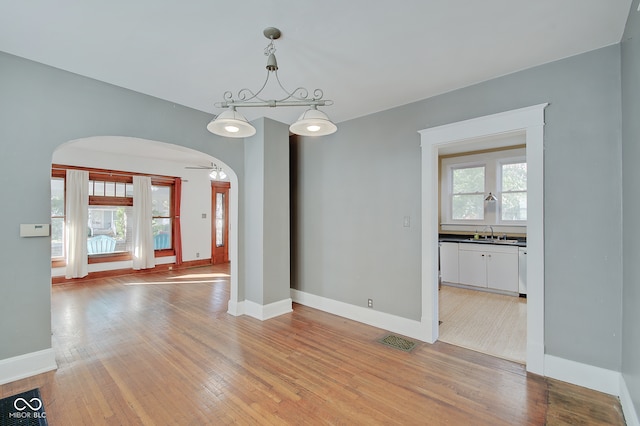 spare room with light hardwood / wood-style floors, ceiling fan, and sink