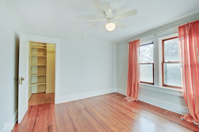 empty room with light hardwood / wood-style flooring, ceiling fan, and crown molding