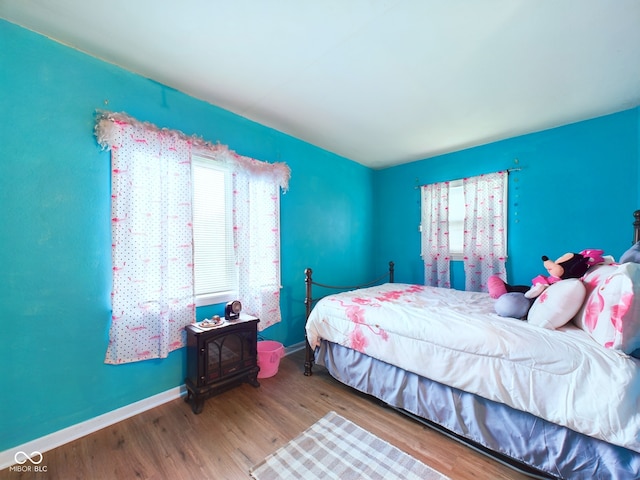 bedroom with wood-type flooring and a wood stove