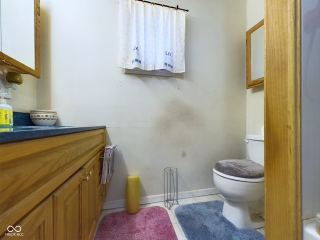 bathroom with tile patterned flooring, vanity, and toilet