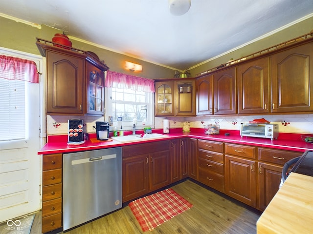 kitchen with sink, stainless steel dishwasher, decorative backsplash, ornamental molding, and dark hardwood / wood-style flooring