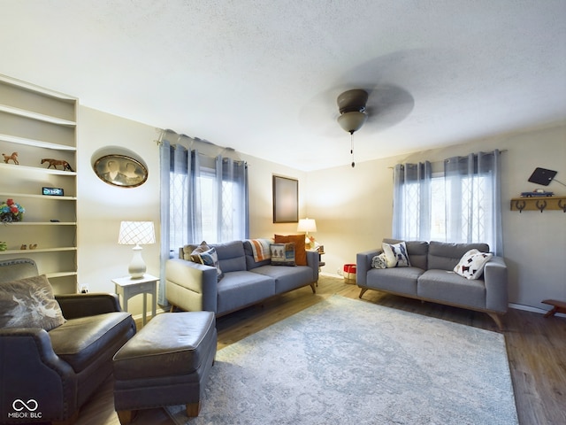 living room with a wealth of natural light, ceiling fan, wood-type flooring, and a textured ceiling