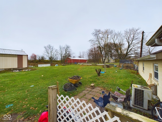 view of yard with cooling unit and a storage unit