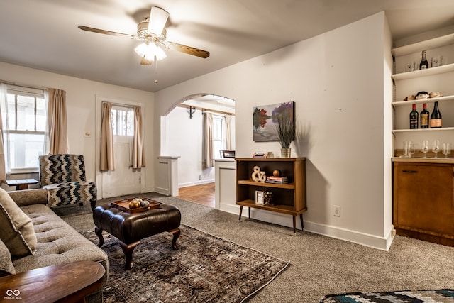 carpeted living room with ceiling fan